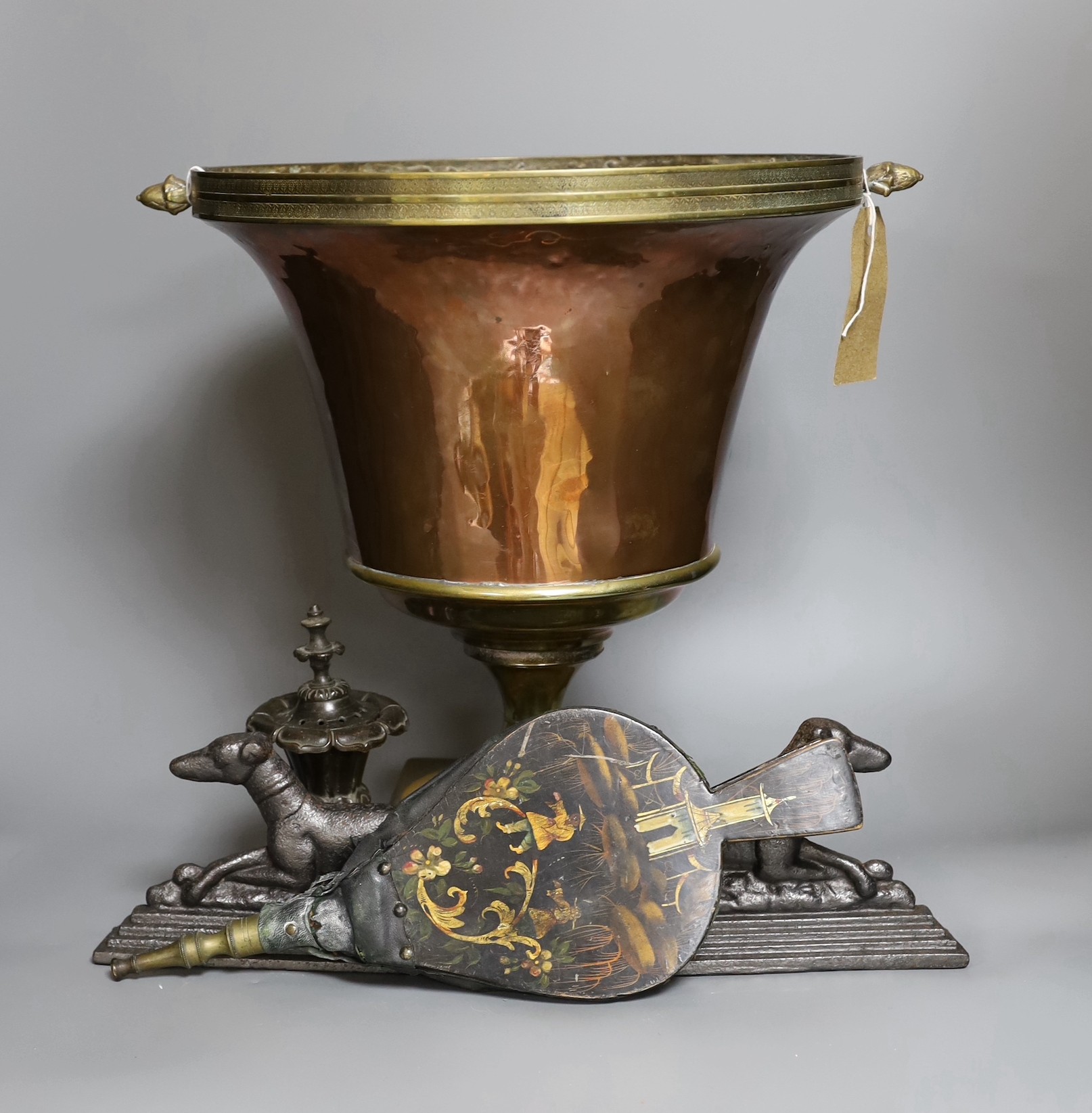 A Victorian copper vase on plinth base, a pair of Victorian cast iron recumbent dog door stops and a Regency bronze censer and cover, and a Victorian lacquered bellow (5)